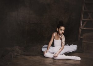 Little adagio ballet dancer sitting on the floor